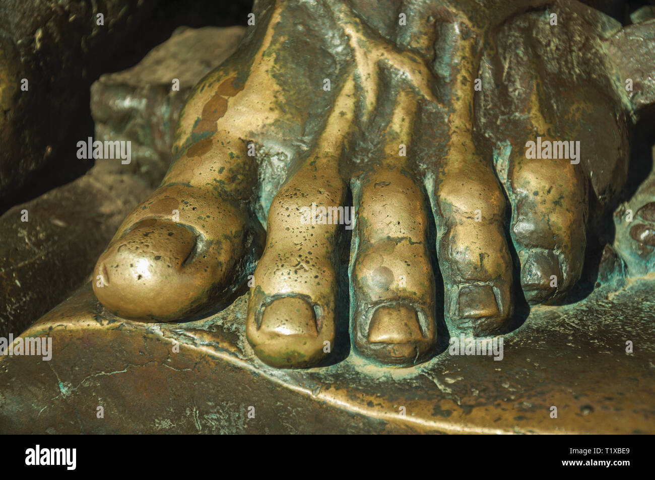 Statua in bronzo dettaglio del piede dal sacerdote su un libro aperto sulla Cattedrale di Caceres. Una città affascinante con una completamente preservato centro storico in Spagna. Foto Stock