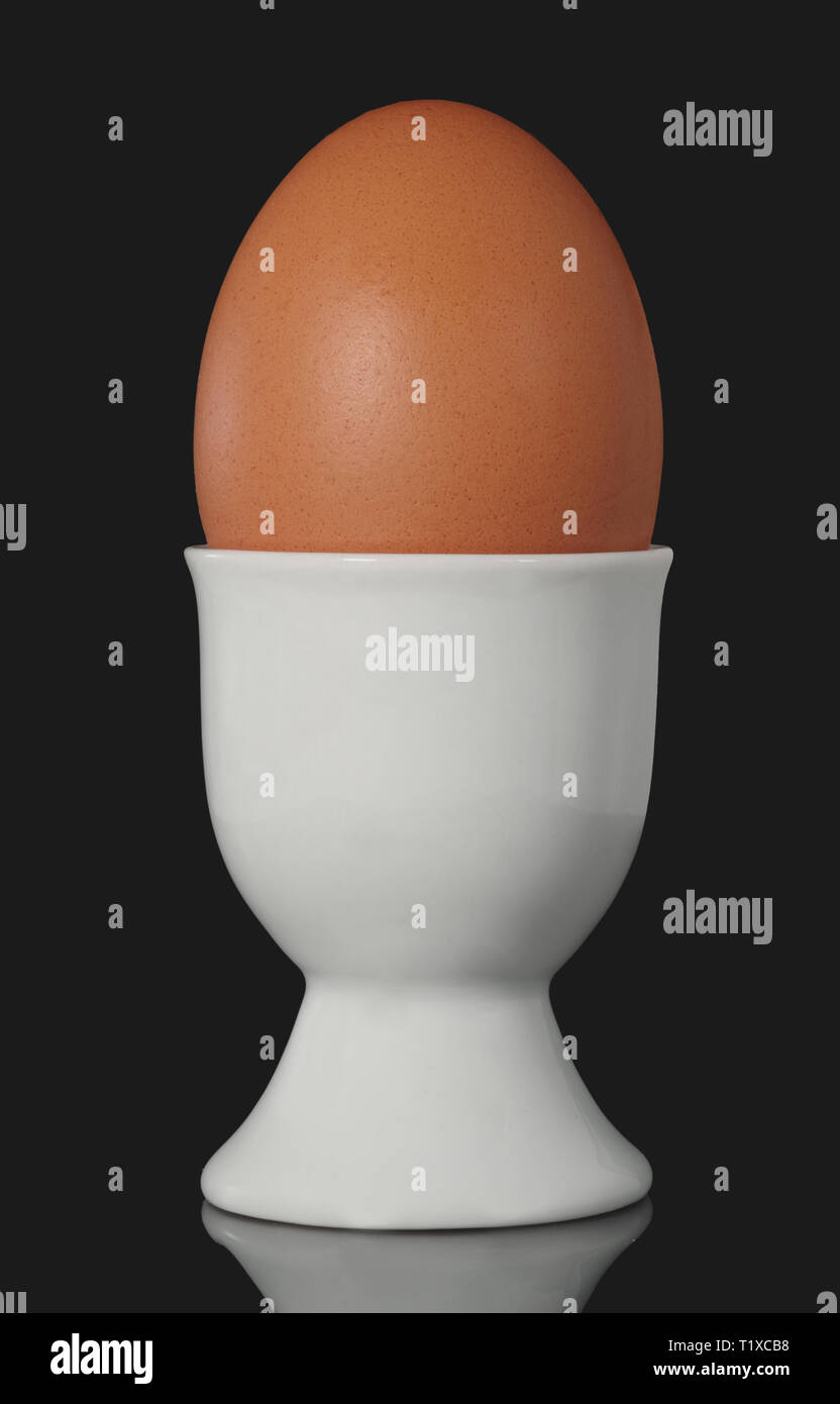 Uovo di gallina uova in tazza isolata su sfondo nero Foto Stock