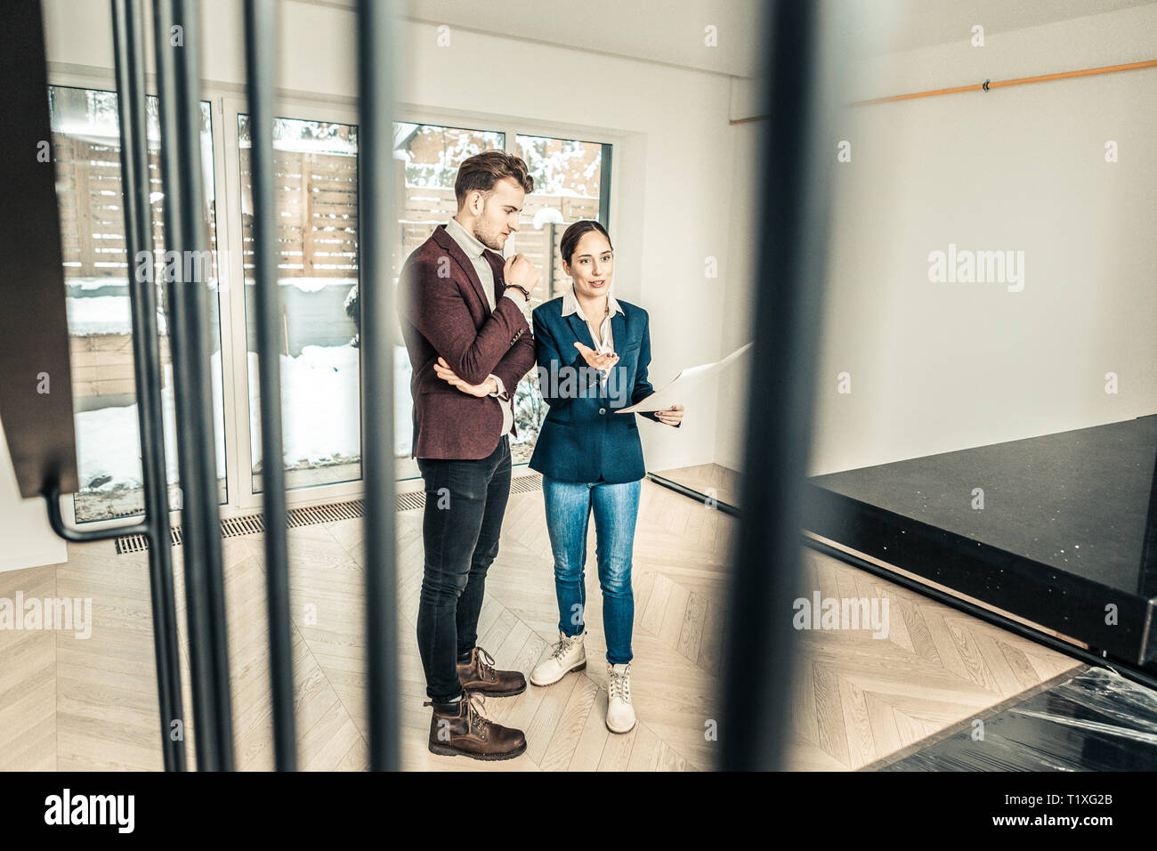 Agente immobiliare che indossa jeans e giacca blu in piedi in camera con il  client Foto stock - Alamy