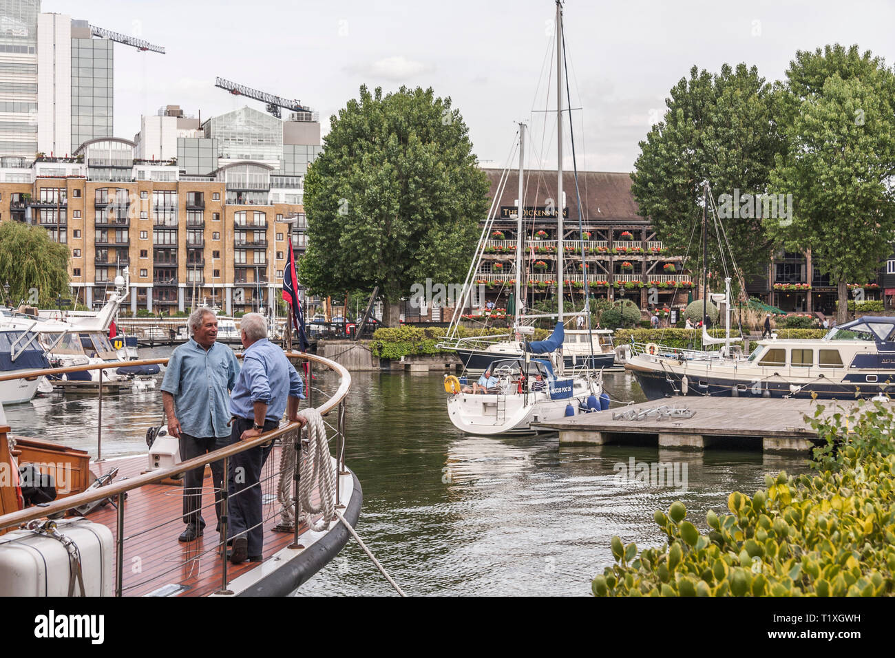 Due uomini maturi stava parlando su una barca a Saint Katherine's Dock marina a Londra Foto Stock