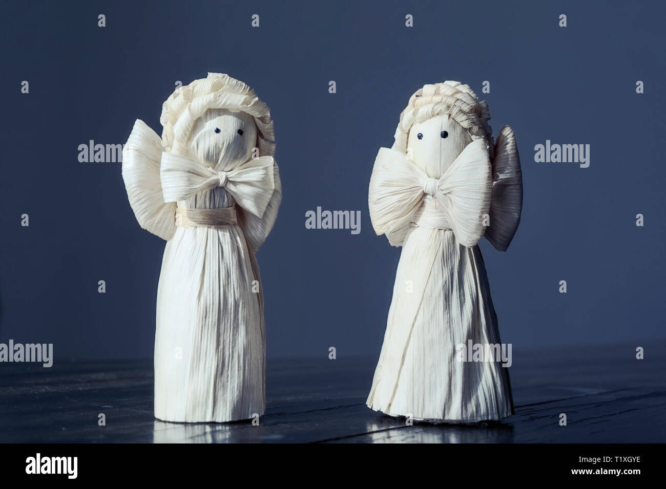 Due handcrafted Corn buccia Angeli figurine permanente sulla incrinato tavolo in legno scuro, toni di mezzanotte, Do it yourself progetto, incredibile craft, cristianesimo, Foto Stock