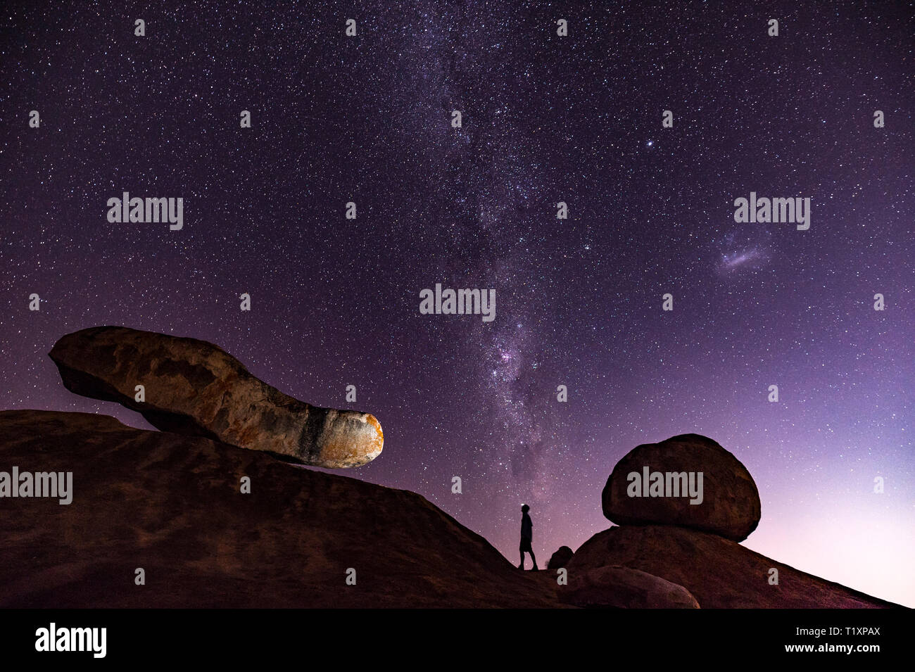 Un uomo orologi un stellato cielo Africano in Zimbabwe. Foto Stock