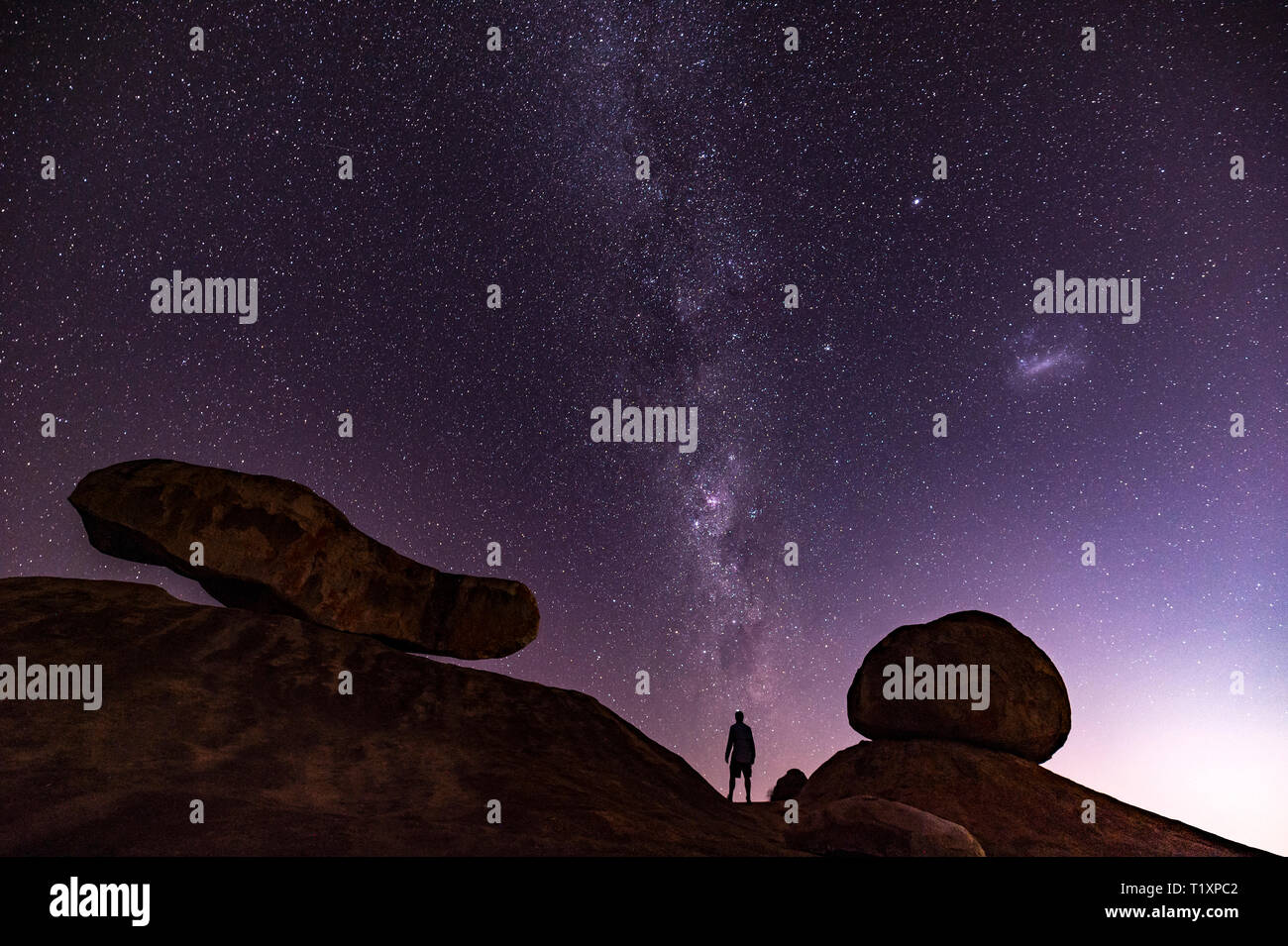 Un uomo orologi un stellato cielo Africano in Zimbabwe. Foto Stock