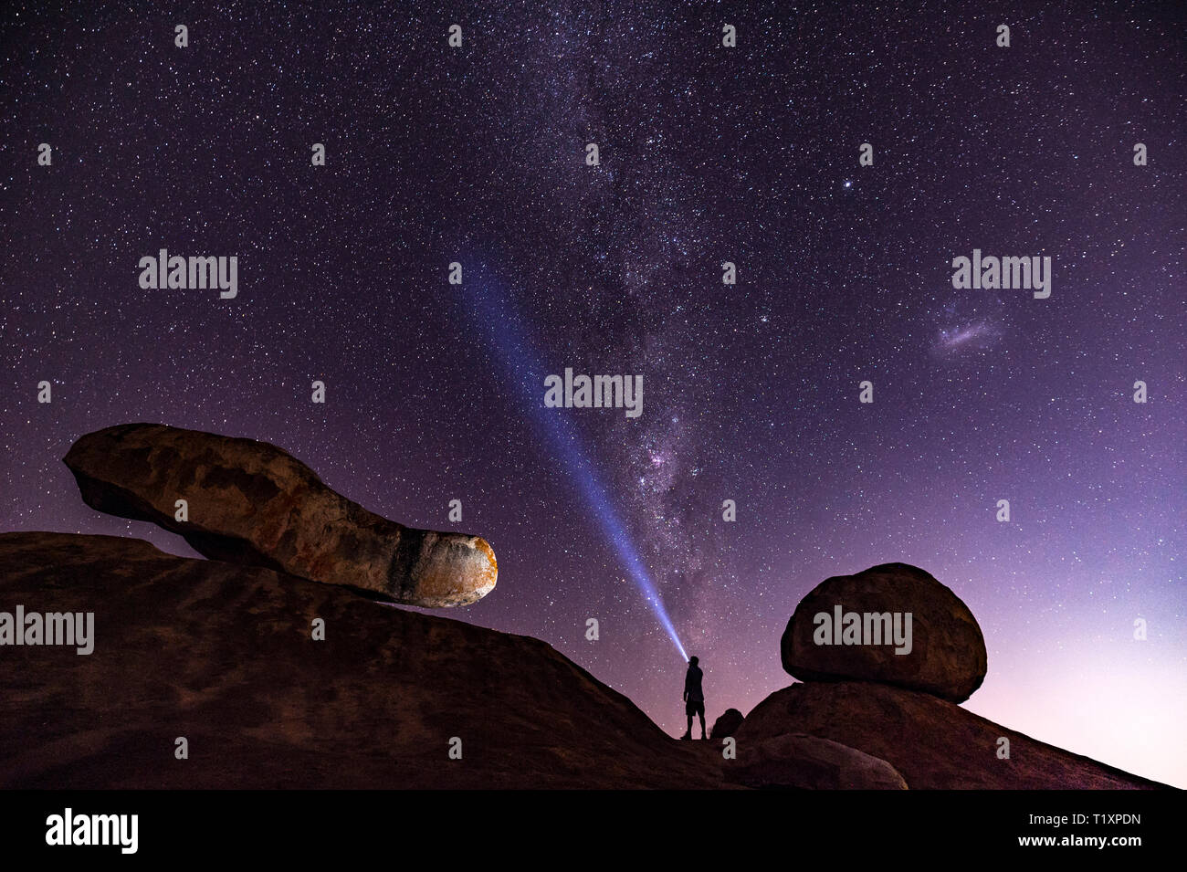 Un uomo orologi un stellato cielo Africano in Zimbabwe. Foto Stock