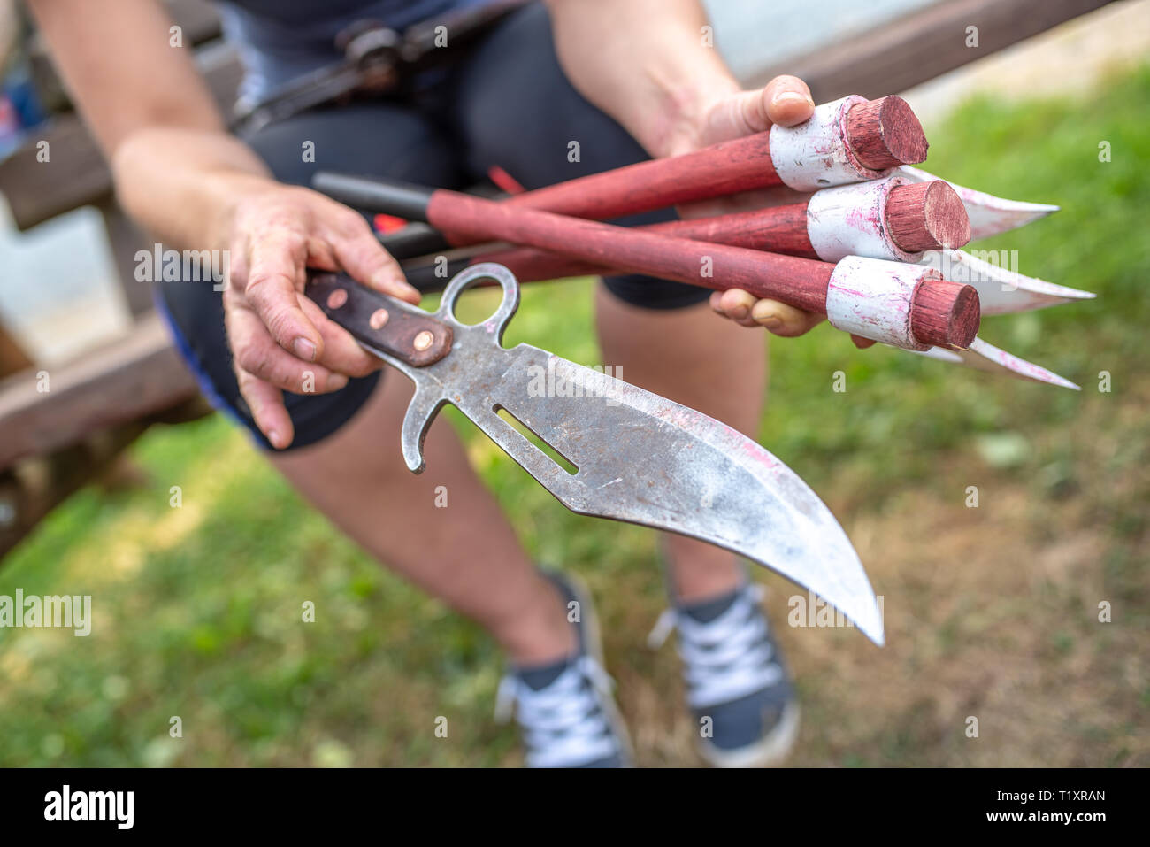 Donna che mantiene il coltello di lancio e tre assi nelle sue mani Foto Stock