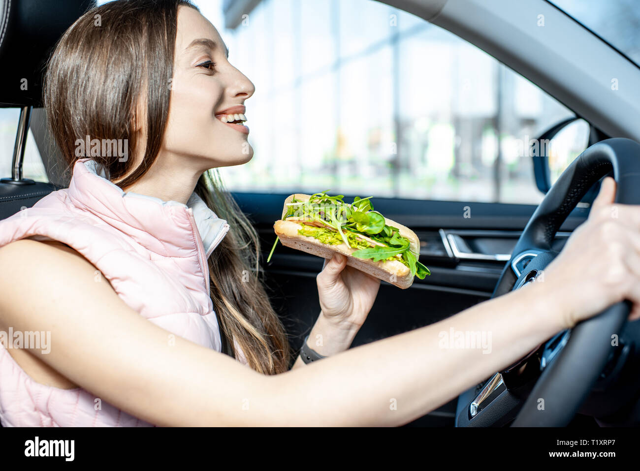 Una donna seduta in una macchina che mangia un panino foto – All'interno  dell'auto Immagine su Unsplash