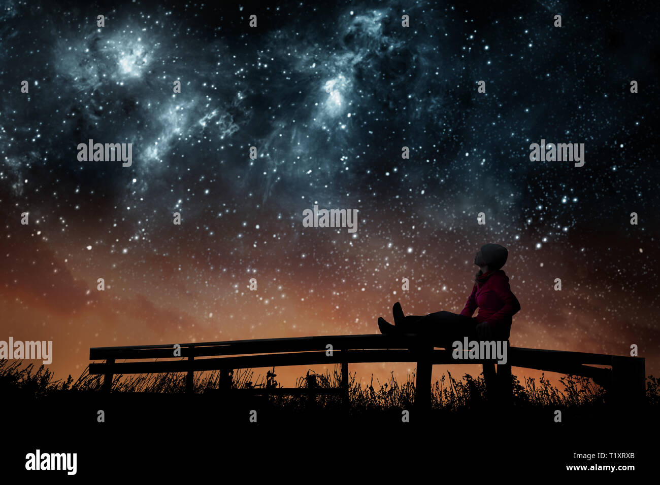 Ragazza guardando le stelle nel cielo notturno Foto Stock