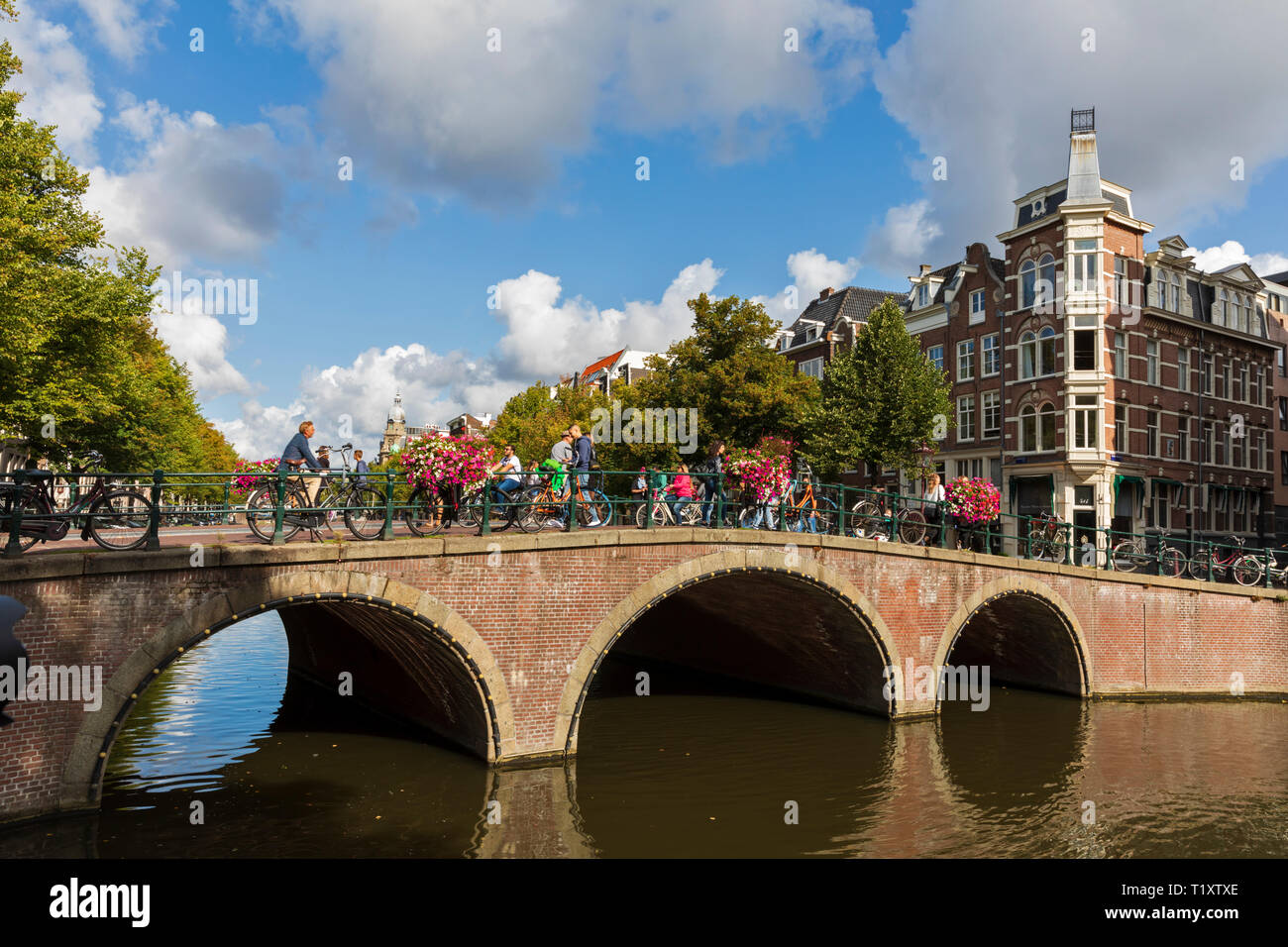 I ciclisti attraversare un ponte sul canale Keizersgracht in Amsterdam, Olanda Settentrionale, Paesi Bassi. Foto Stock