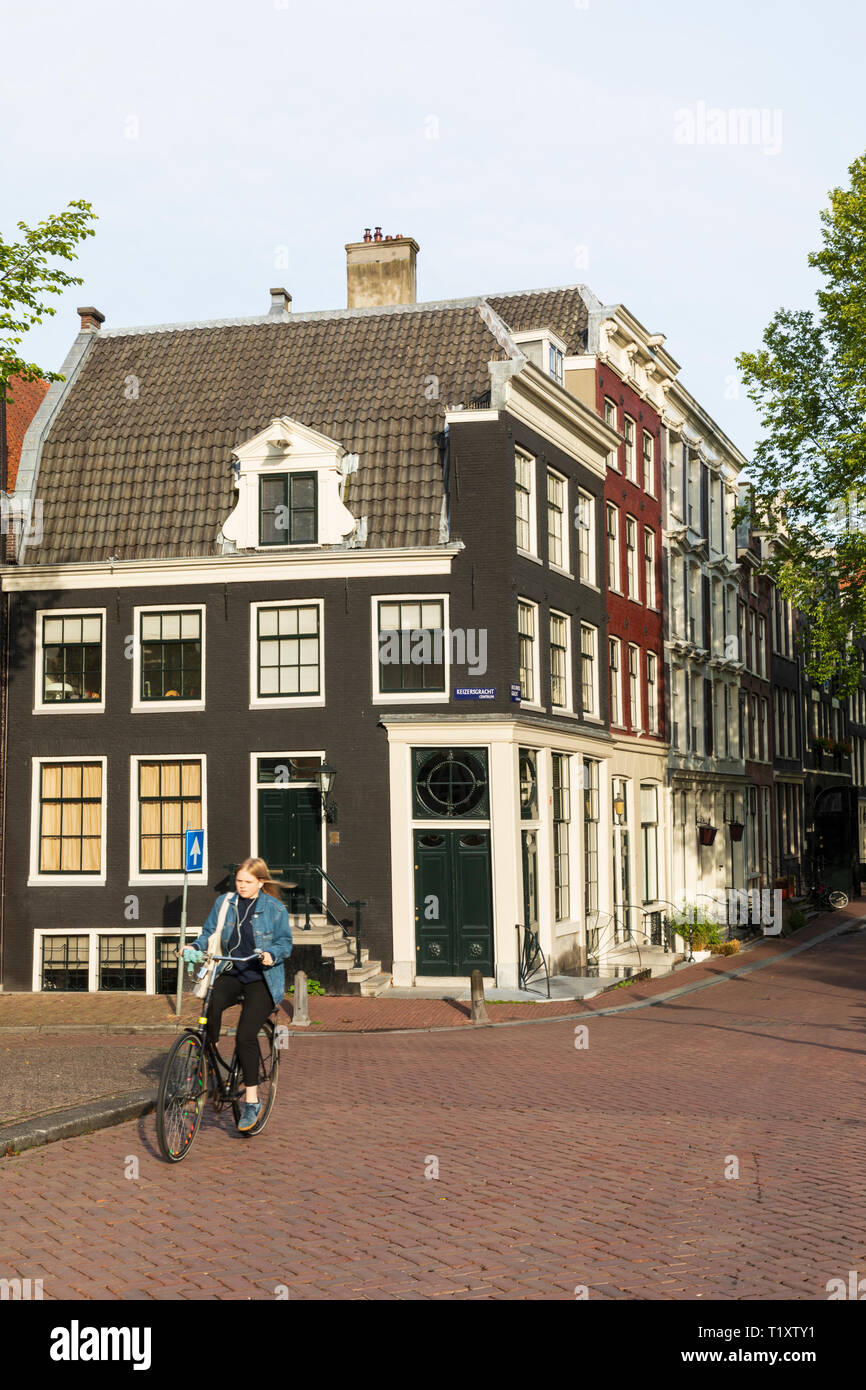 Un ciclista passa di tipiche case olandese sulla intersezione di Brouwersgracht canale e canale Keizersgracht ad Amsterdam in Olanda. Foto Stock