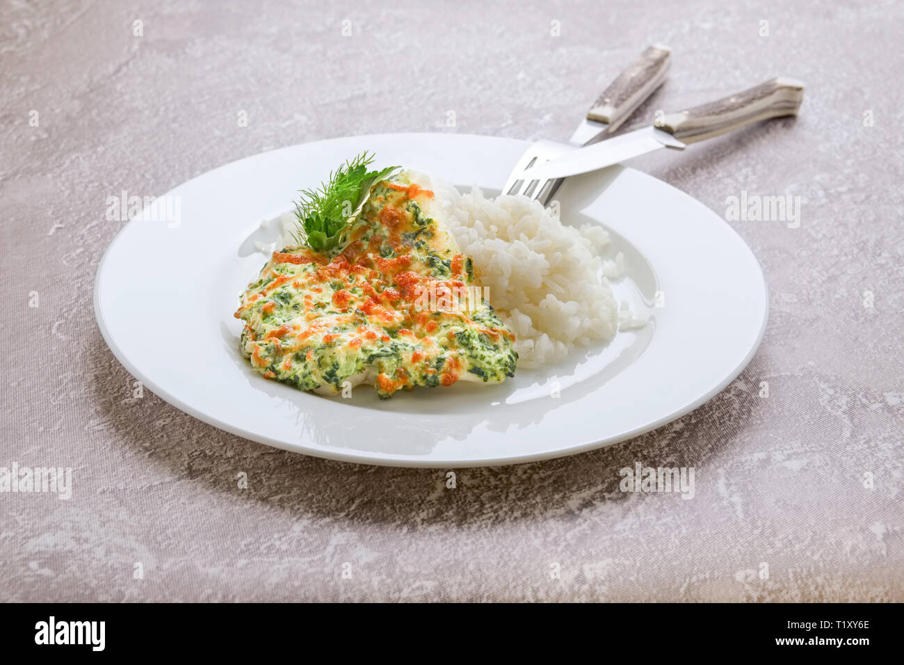Nasello fritto di filetto con spinaci, formaggio e riso Foto Stock