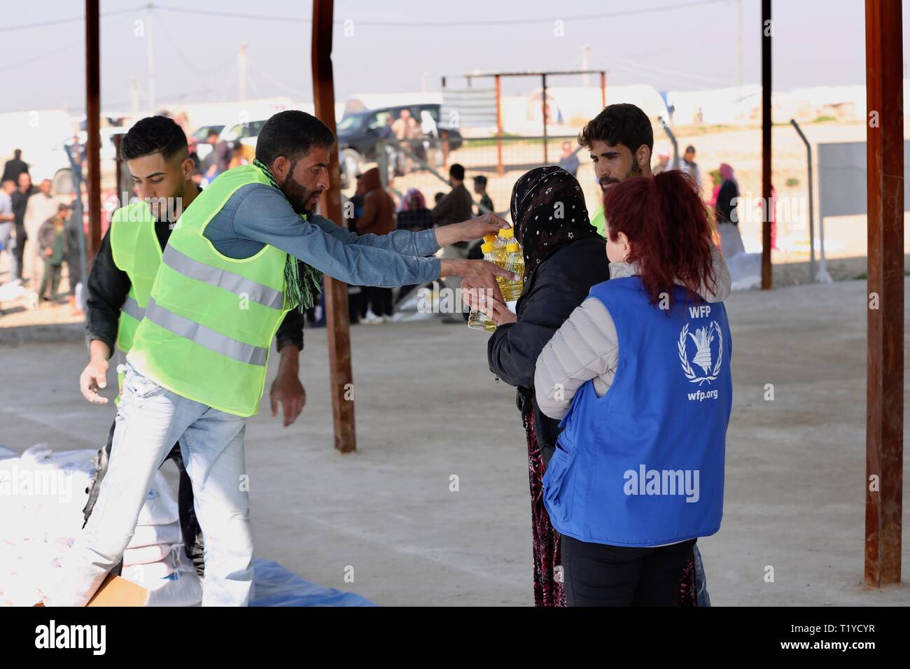 (190329) -- di Mosul, Marzo 29, 2019 (Xinhua) -- il personale lavora distribuire cibo in rilievo di al-Salamiyah 1 camp, una trentina di km a sudest dell'Iraq settentrionale della città di Mosul, Iraq, 6 marzo 2019. Dopo più di un anno dopo la vittoria militare contro gli estremisti islamici membro (SI) militanti, centinaia di migliaia di iracheni sfollati interni sono ancora bloccati nei campi di concentramento, rivolta verso la scarsità di cibo mentre prive di opportunità di lavoro e servizi di base a tornare a casa. (Xinhua/Khalil Dawood) PER ANDARE CON FUNZIONE: rifugiati iracheni bloccati nei campi di concentramento, mancanza di opportunità per tornare Foto Stock