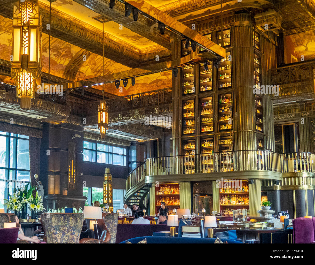Armadio alto o gin tower con vetro e colonne in legno intagliato il fulcro della Atlas bar nella lobby di Parkview Square Singapore. Foto Stock