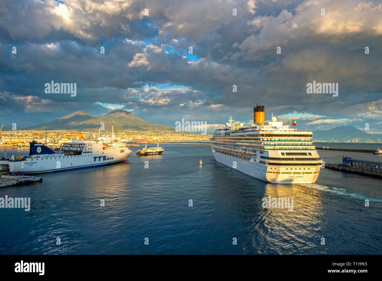 L'ITALIA, NAPOLI, nave da crociera "Costa Serena' che lascia il porto di Napoli nel tardo pomeriggio con il Vesuvio sullo sfondo Foto Stock