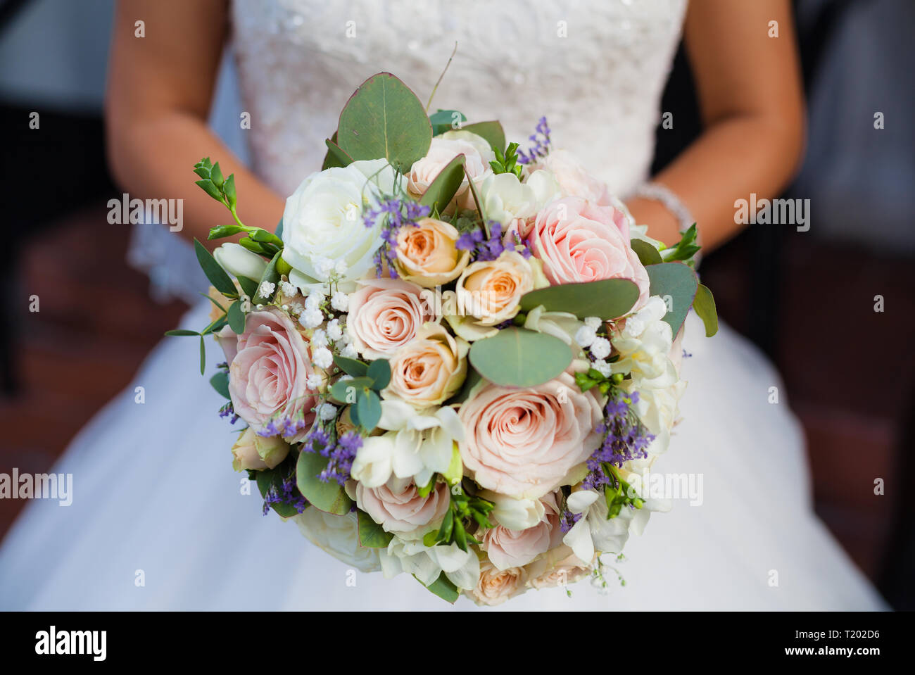 Bellissimo mazzo di nozze nella mani della sposa. Rose, cotone, rose. Rosa, Bianco e pesca. Alla moda e moderno e fiori di nozze. Delicati colori pastello. Foto Stock