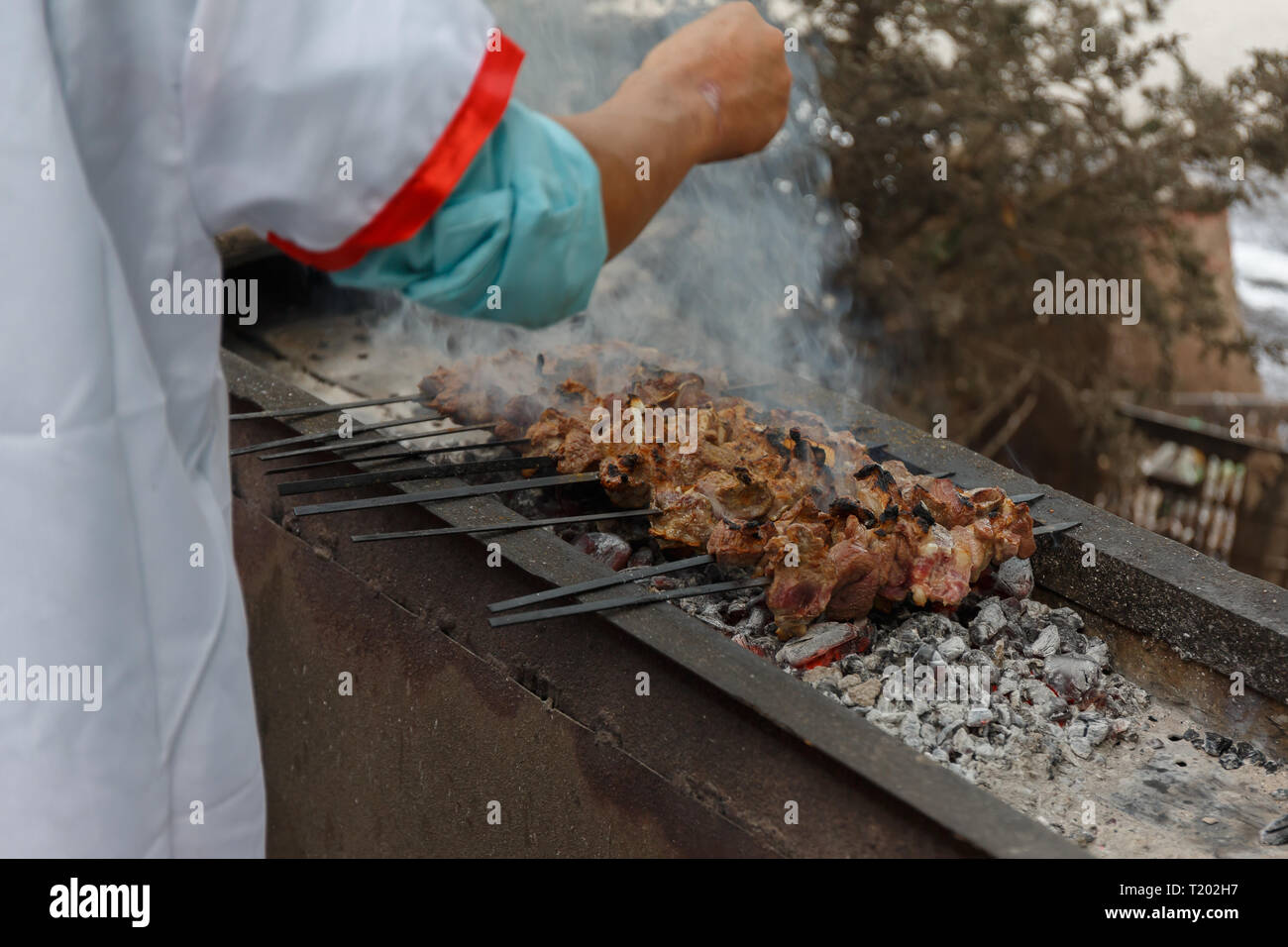 Spiedini di agnello - uno dei più tradizionali specilties uigura - vengono preparati in un bazaar di Kashgar Foto Stock