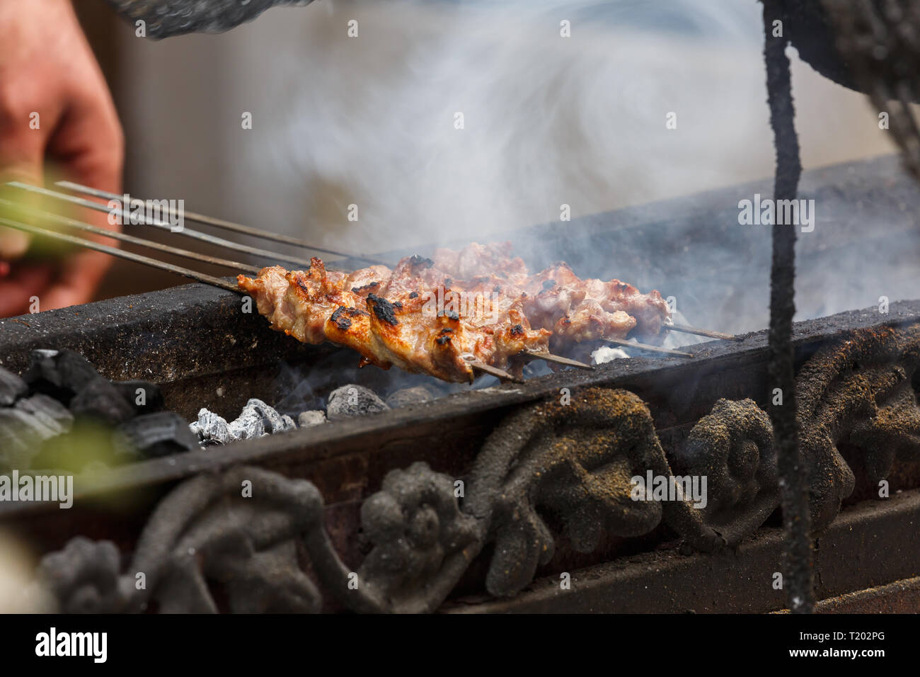 Spiedini di lampada essendo grigliate in un bazar da uno chef locale (Kashgar, provincia dello Xinjiang, Cina) Foto Stock