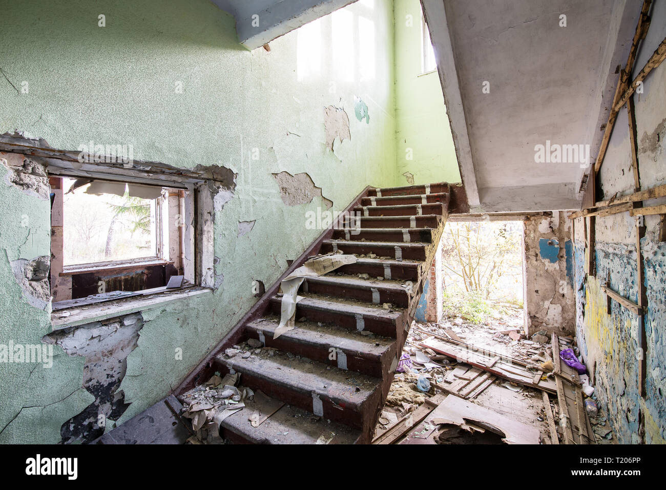 Scala di cemento nel vecchio abbandonato casa rovinata indoor sulla giornata di sole Foto Stock