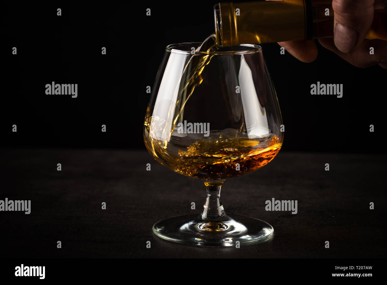 Versando il brandy o il cognac in vetro. Foto Stock