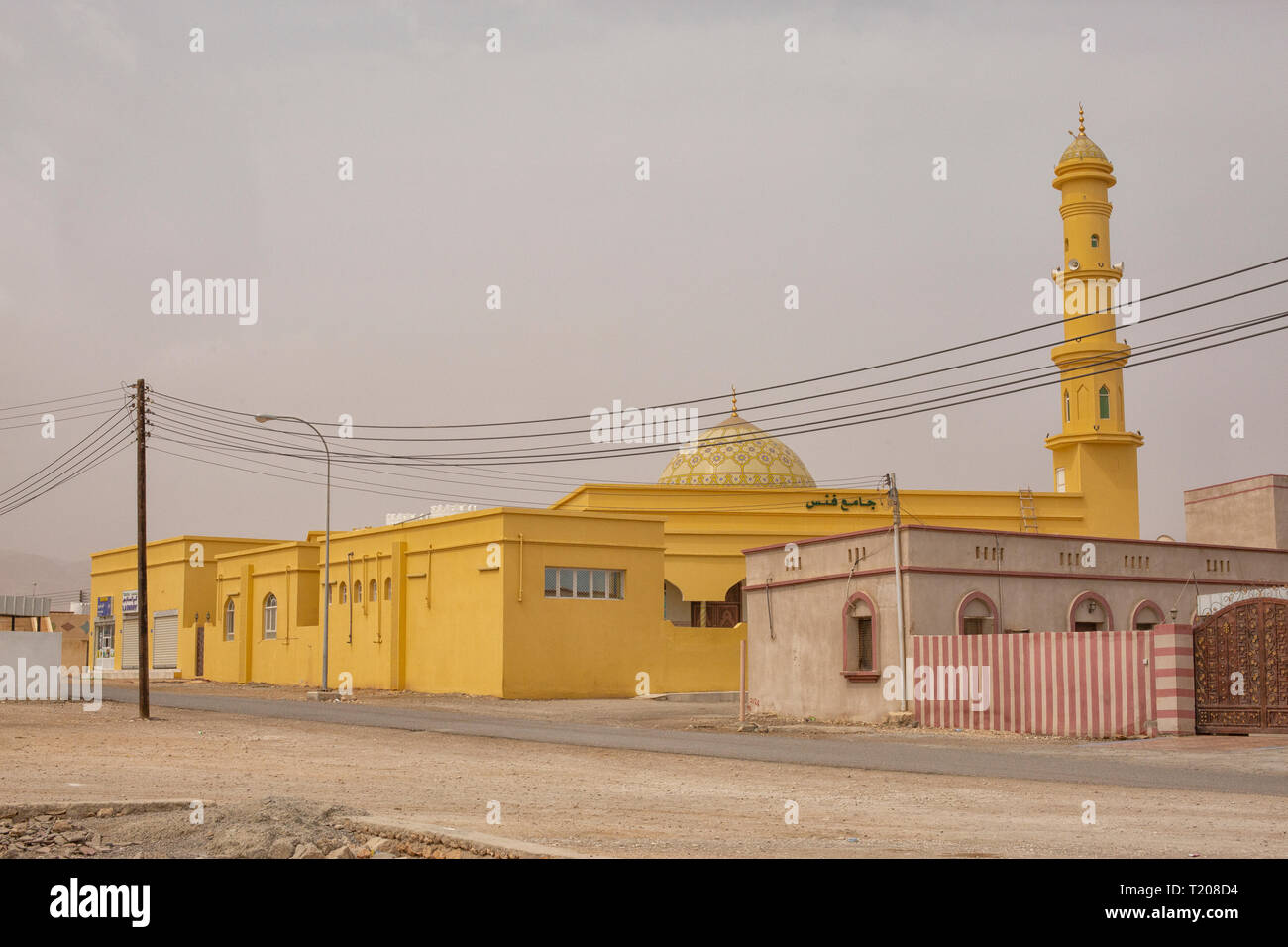 La moschea di colore giallo nel villaggio vicino a Spiaggia di alette in Oman Foto Stock
