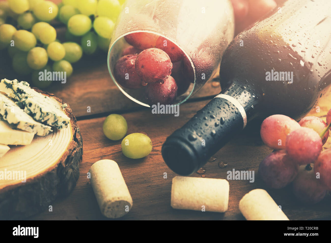 Bottiglia di vino rosso con uva e formaggio blu Foto Stock