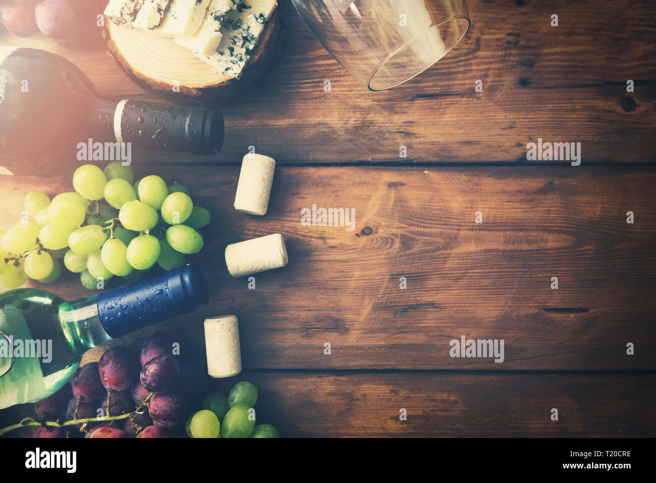 Le bottiglie di vino di uve e formaggio su sfondo di legno. top view copyspace Foto Stock