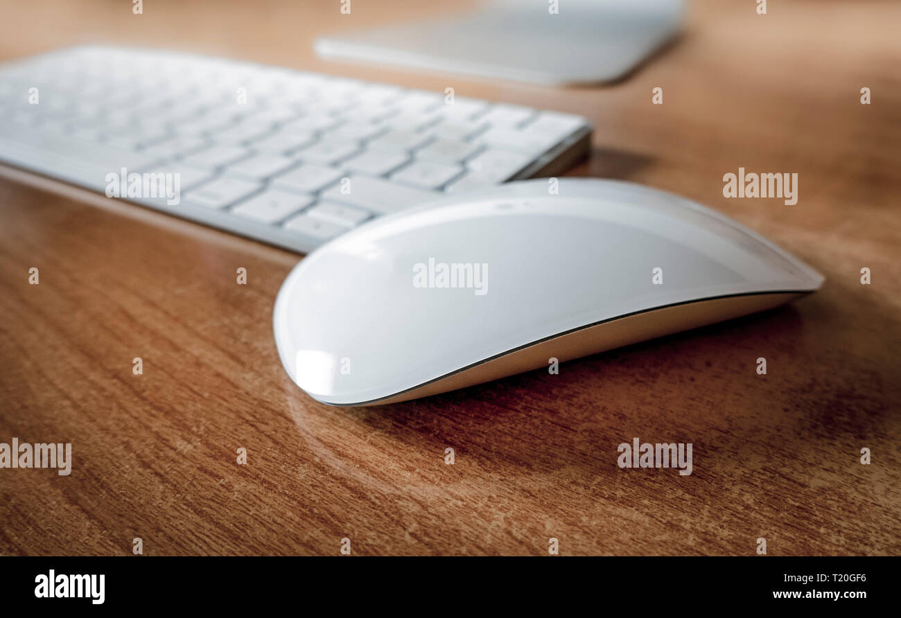 Bianco mouse wireless sulla scrivania in ufficio con tastiera dietro. Foto Stock