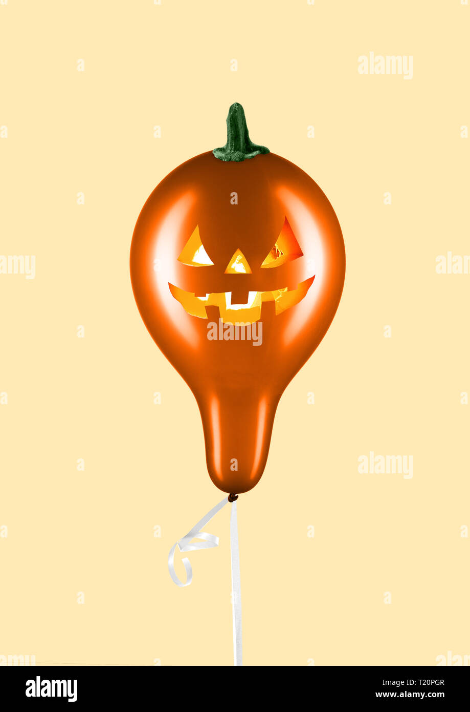 Festa di Halloween. Il design moderno. L'arte contemporanea collage. Oro palloncino formato zucca con candele all'interno contro la luce dello sfondo. Minimal Art. Lo spazio negativo per inserire il tuo testo. Foto Stock