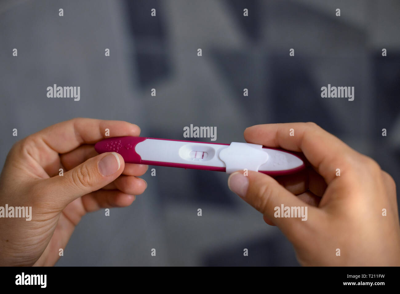 Close-up di donna di mani positivi ai test di gravidanza Foto Stock