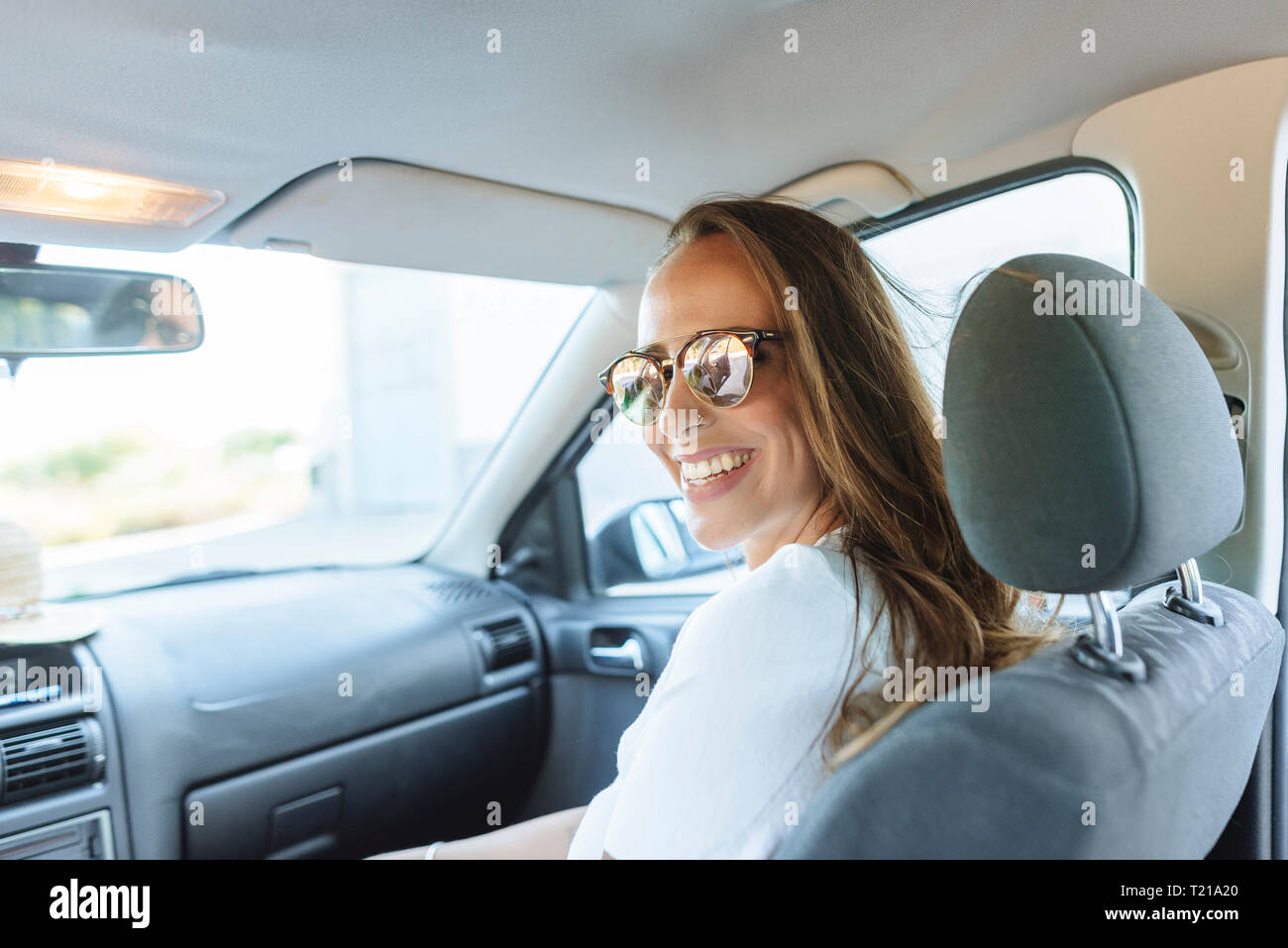 Donna felice sul sedile del passeggero in auto Foto Stock
