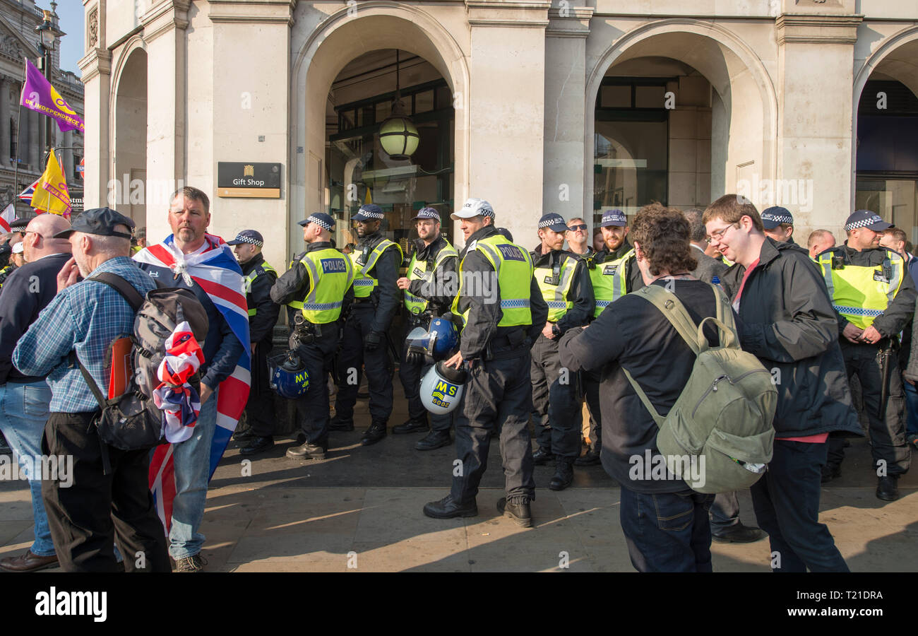 Westminster London, Regno Unito. 29 marzo, 2019. Migliaia di sostenitori di lasciare raccogliere al di fuori del Parlamento come MPs respingere il primo ministro per il ritiro di trattare con 58 voti. Marzo a lasciare il rally si raccoglie in piazza del Parlamento per ascoltare Nigel Farage parlare. Un separato rendono accadere Brexit rally avviene in Whitehall, organizzata dall'UKIP con EDL di Tommy Robinson. La polizia antisommossa con ingranaggio in attesa sulle strade adiacenti. Credito: Malcolm Park/Alamy Live News. Foto Stock