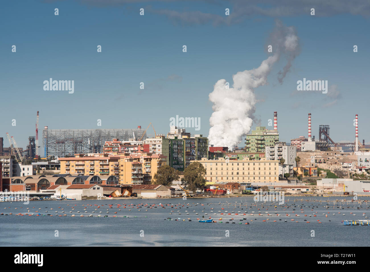 Il front-end di un impianto siderurgico, con una nave portarinfuse con il minerale di ferro in fase di scaricamento Foto Stock