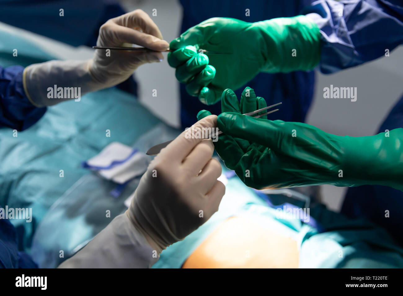 I chirurghi azienda bisturi chirurgico e forcipi in sala operatoria durante  un intervento chirurgico in ospedale Foto stock - Alamy