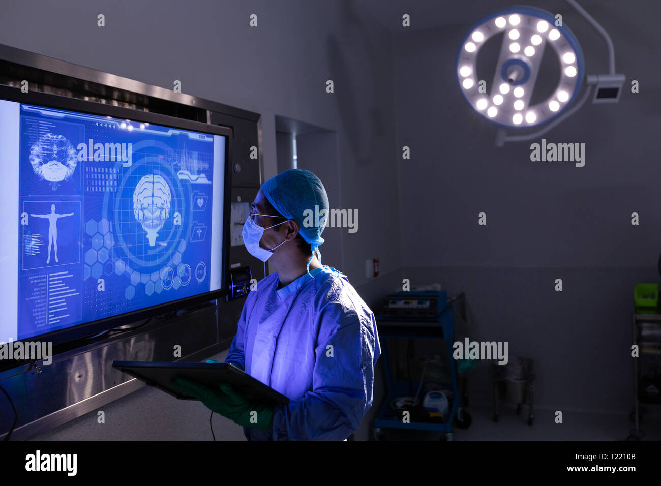 Chirurgo maschio guardando lo schermo in sala operatoria in ospedale Foto Stock