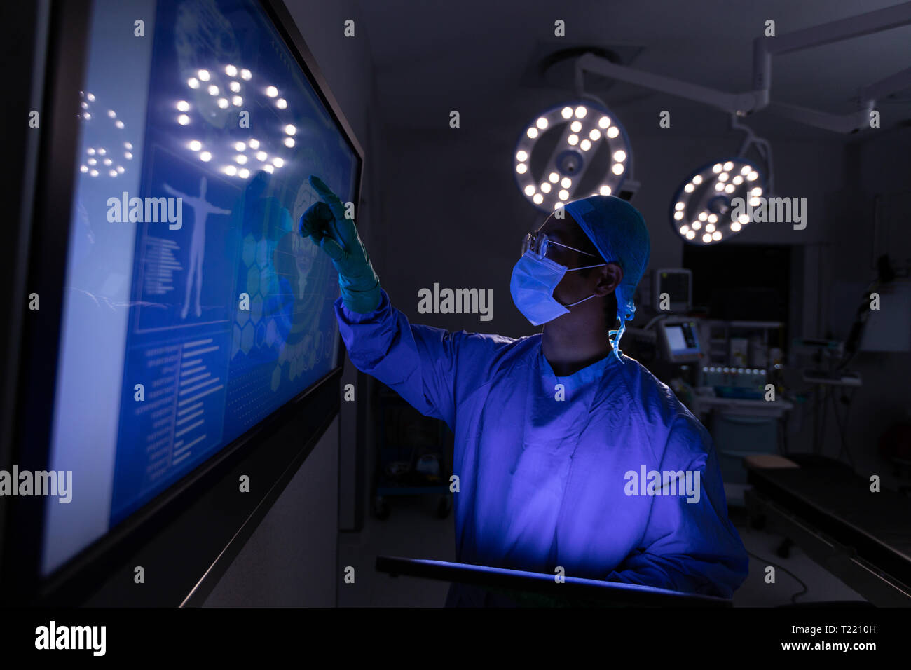 Chirurgo maschio guardando lo schermo in sala operatoria in ospedale Foto Stock