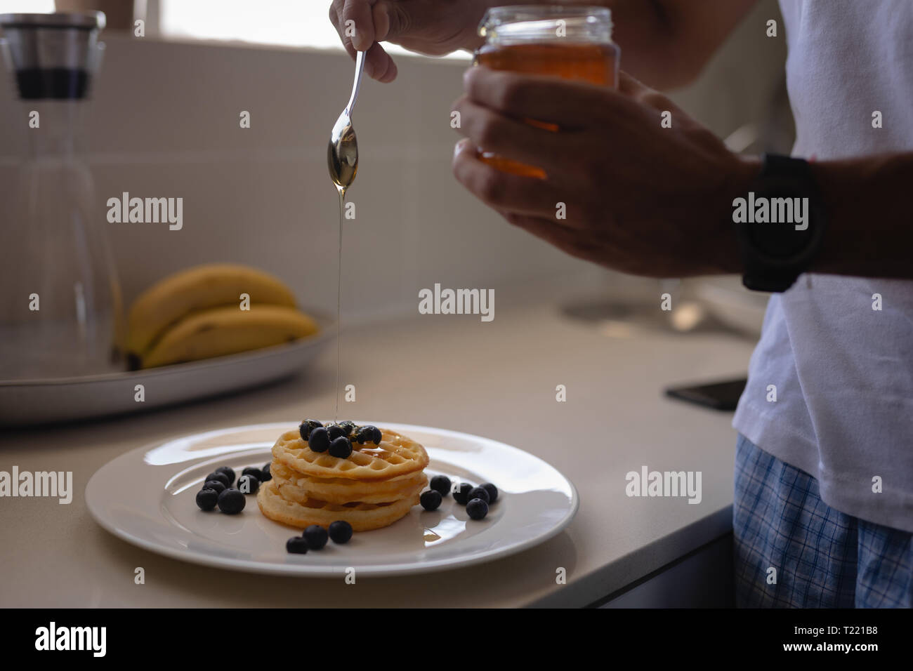 L'uomo prepara la colazione in cucina a casa Foto Stock