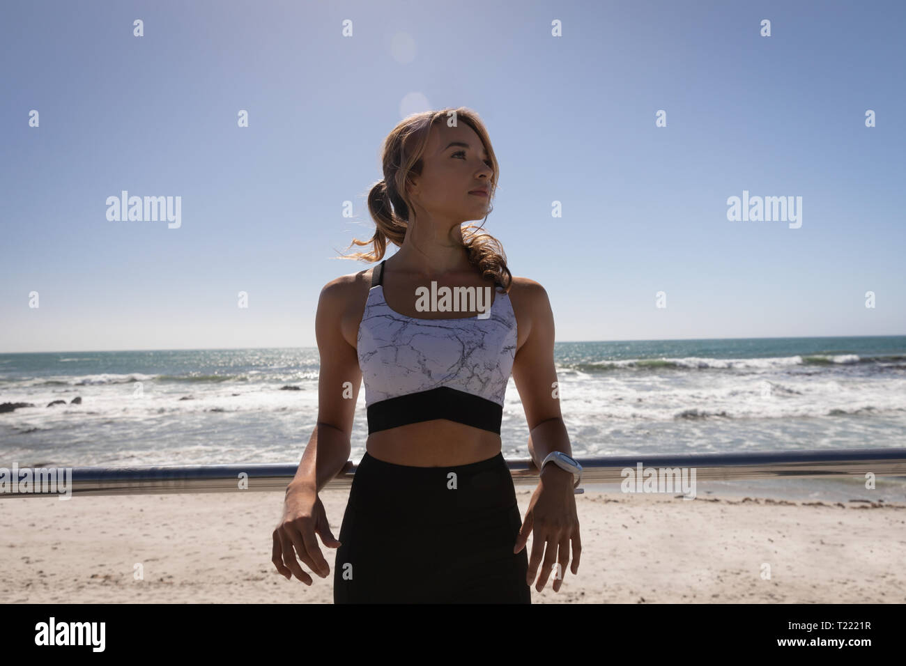 Bella donna in piedi vicino al mare a promenade in una giornata di sole Foto Stock