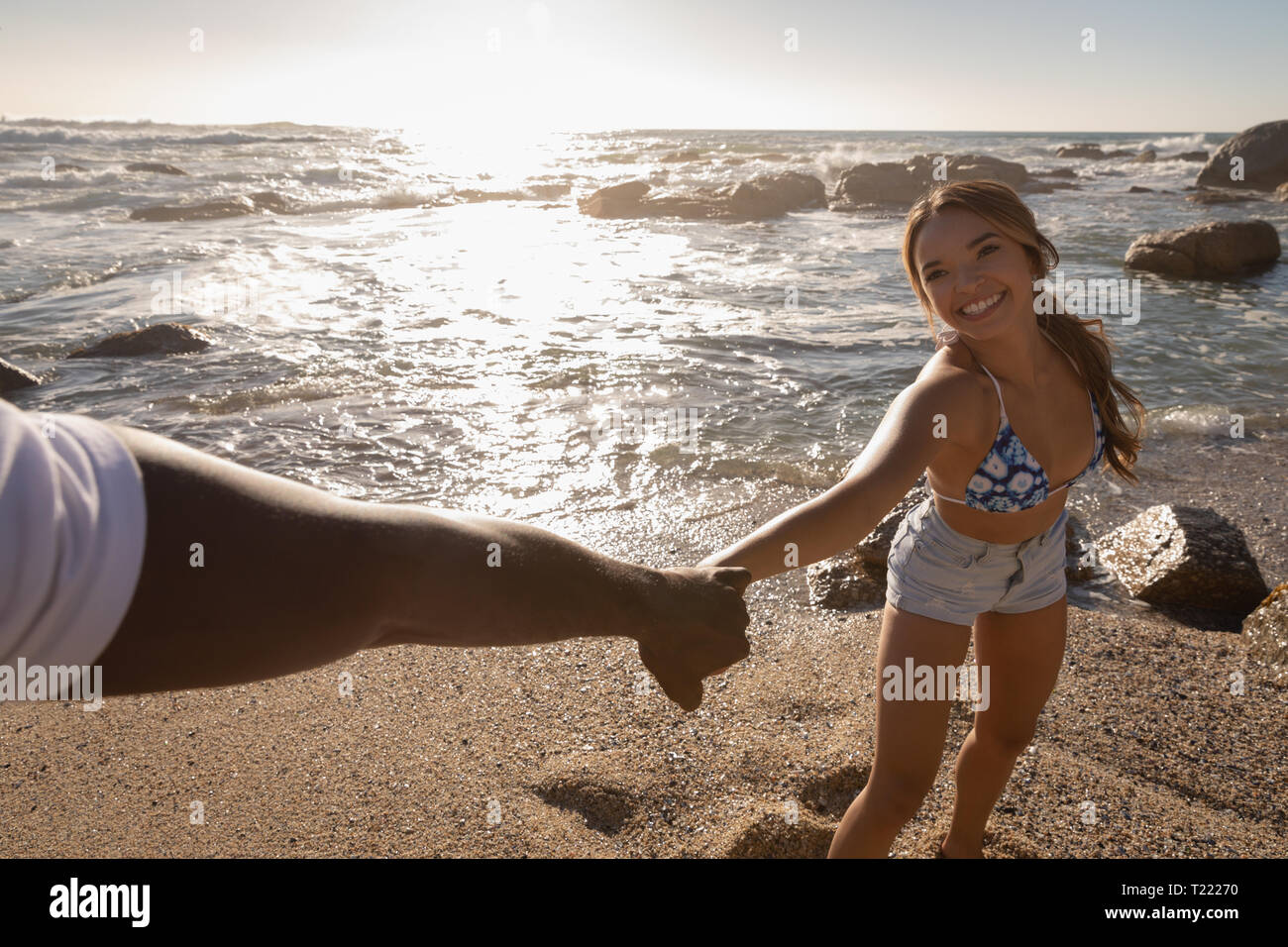 Giovane godendo presso la spiaggia in una giornata di sole Foto Stock