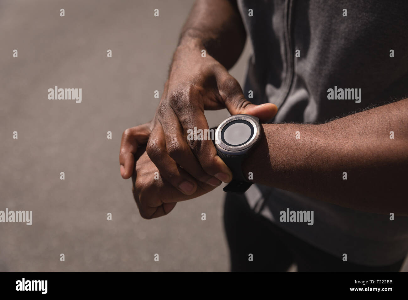 Uomo che guarda un orologio intelligente su strada Foto Stock