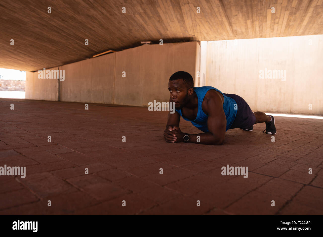 L'uomo facendo esercizio tavoloni sotto il ponte Foto Stock