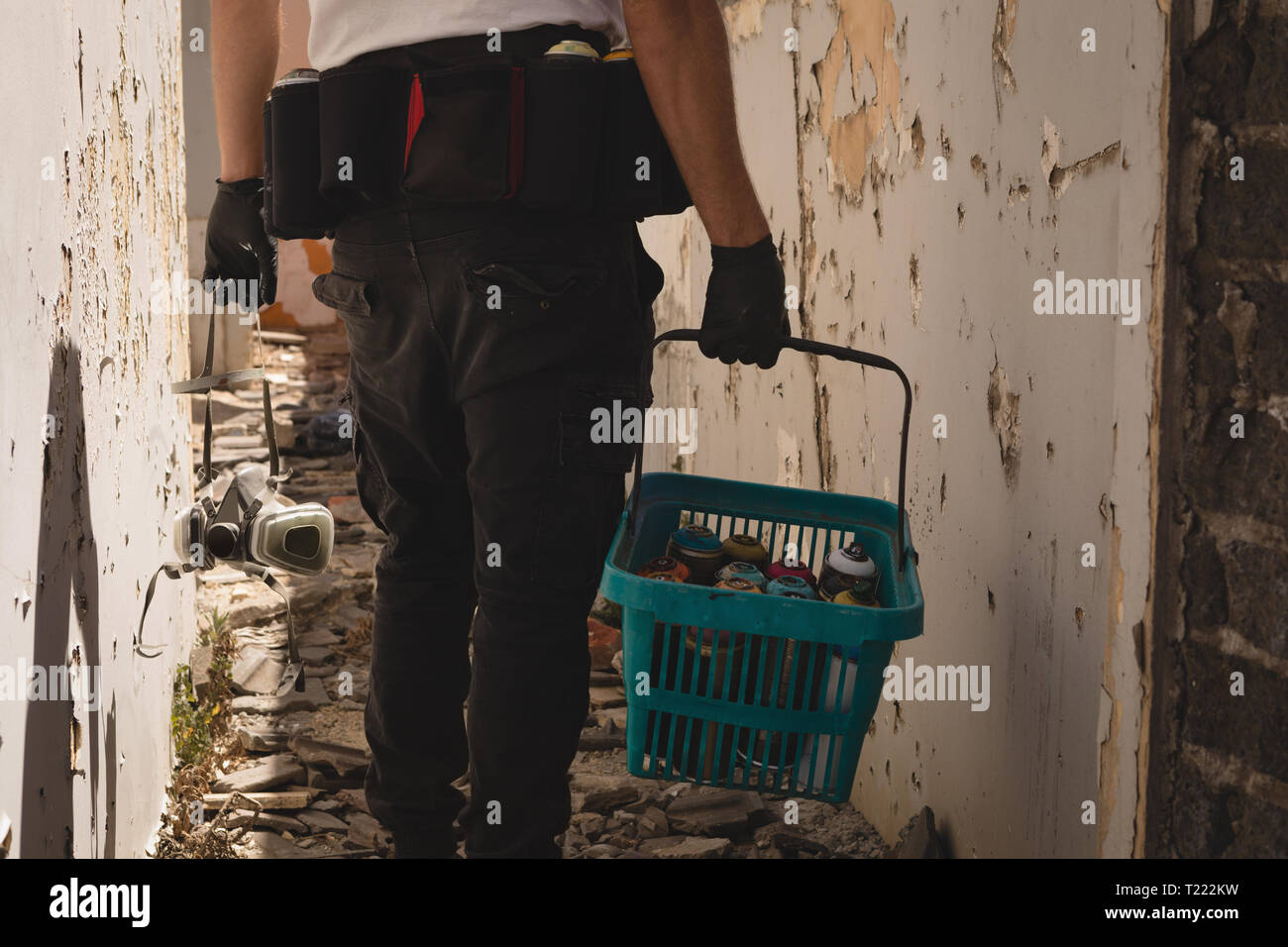 Artista di graffiti a piedi con cesto di vernice spray Foto Stock