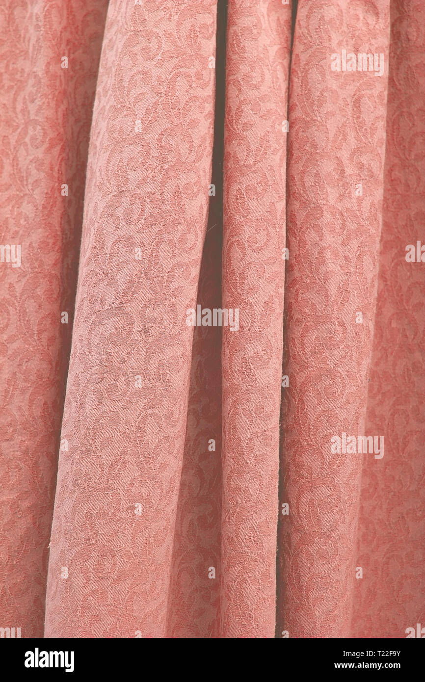Bella piegato damasco tessuto di cotone intessuto texture di sfondo verticale in tonalità colore trend coralli viventi. Foto Stock