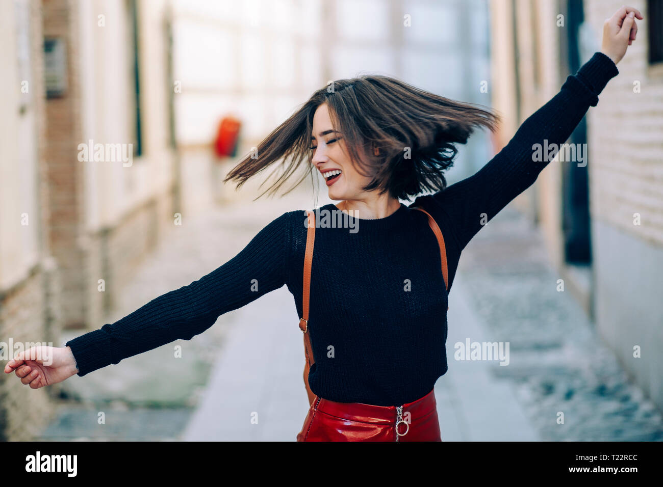 Felice giovane donna ballare in strada Foto Stock