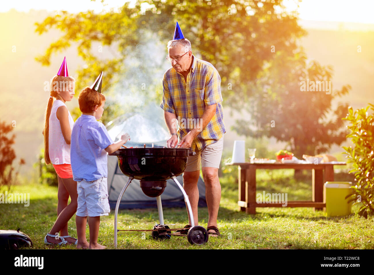 E per il divertimento di tutta la famiglia barbecue party in posizione di parcheggio Foto Stock