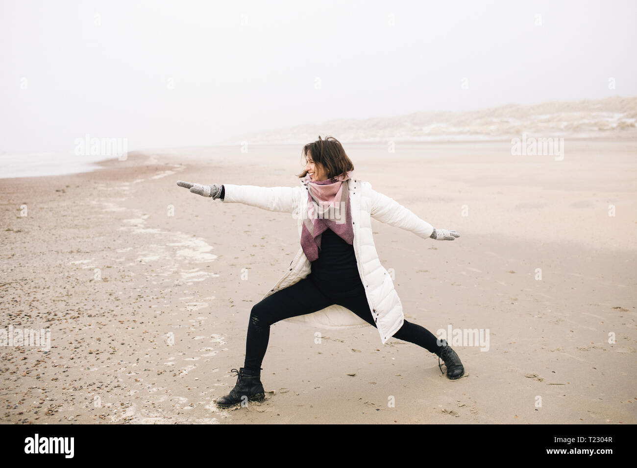 Donna facendo esercizio di yoga sulla spiaggia Foto Stock