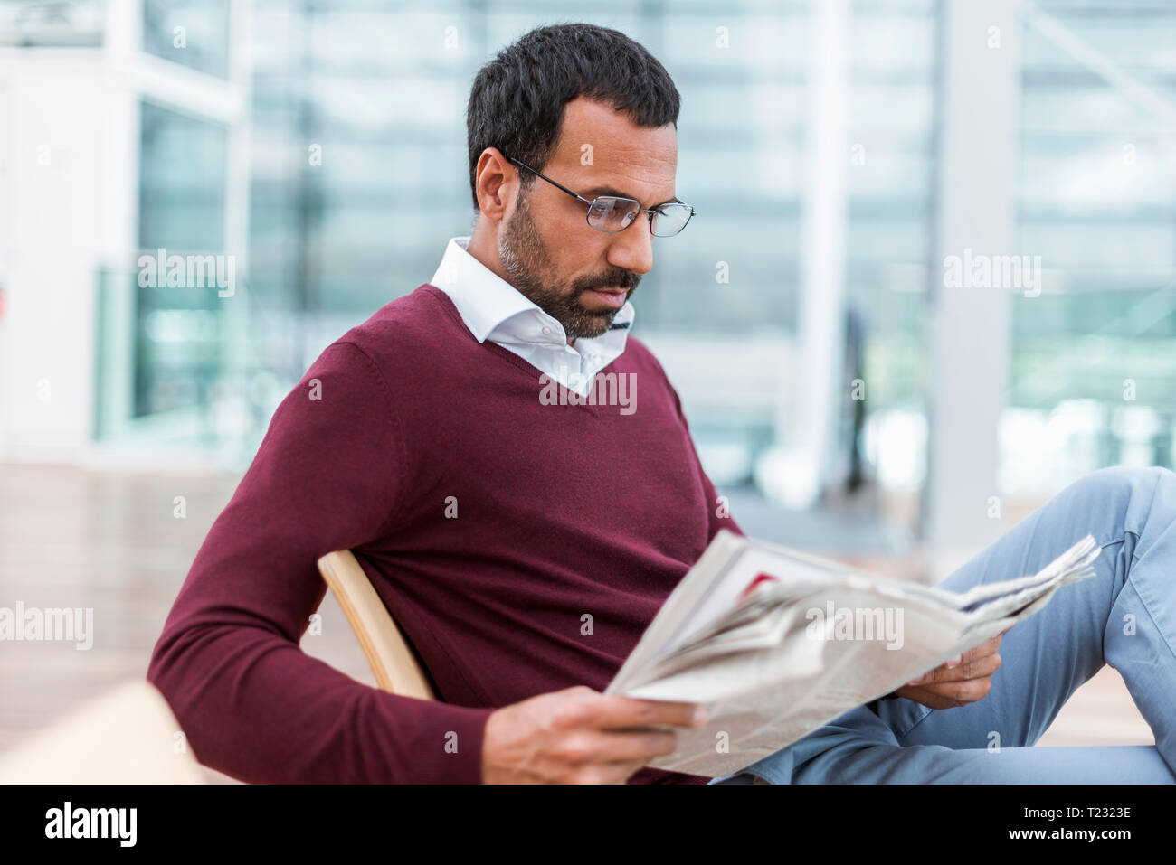 Imprenditore leggendo un giornale in sala di attesa Foto Stock