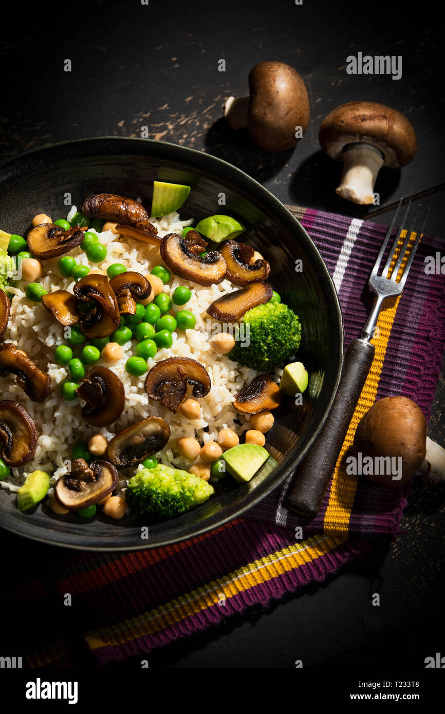 Piatto vegano: naturale riso con champignon, piselli, ceci, avocado e broccoli Foto Stock