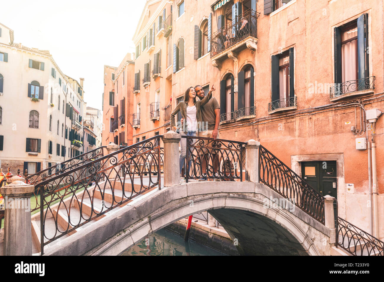 L'Italia, Venezia, coppia giovane in piedi su un piccolo ponte di esplorare la città Foto Stock