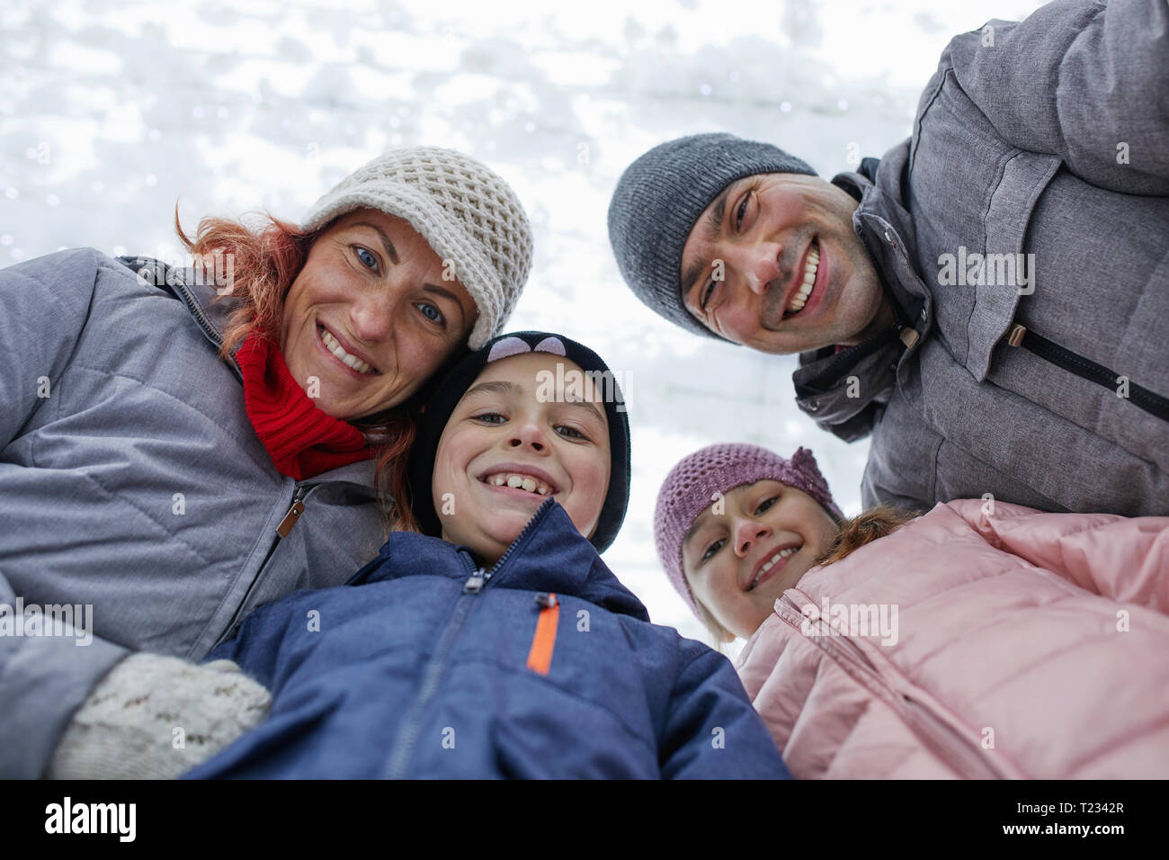 Famiglia con due bambini sulla pista di pattinaggio su ghiaccio, ritratto Foto Stock