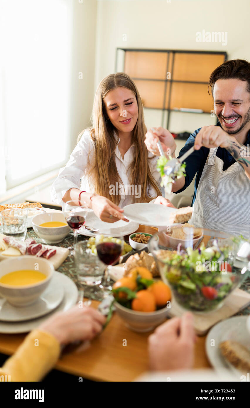 Amici divertendosi, mangiare pranzo insieme Foto Stock