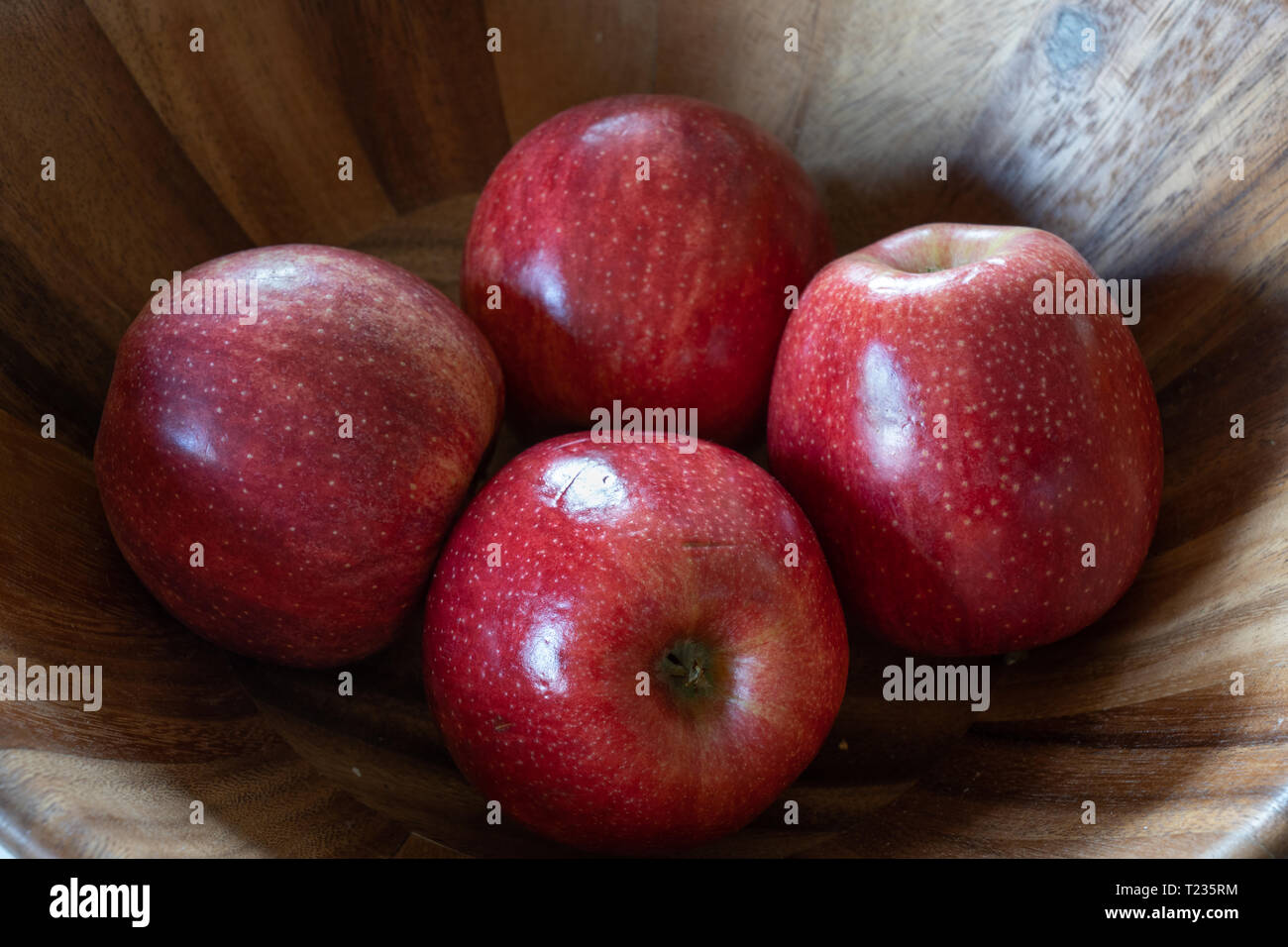 4 mele in una ciotola di legno Foto Stock